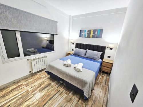 a bedroom with a bed with two towels on it at Las Victorias Suites Bariloche in San Carlos de Bariloche