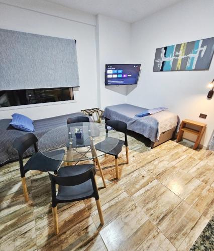 a room with two beds and a table and chairs at Las Victorias Suites Bariloche in San Carlos de Bariloche
