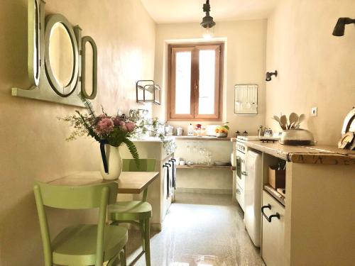 une cuisine avec un vase de fleurs sur une table dans l'établissement Amaretto, à Tivoli