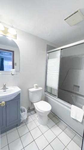 Un baño blanco con inodoro y lavabo. en Commons Inn, en Halifax