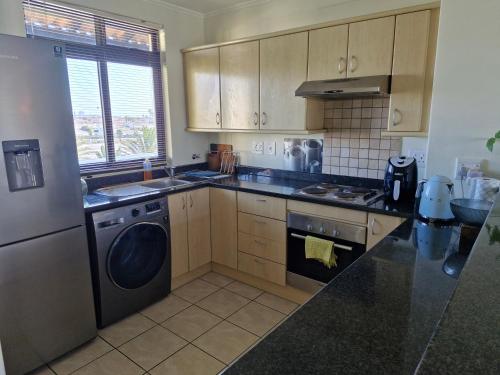 a kitchen with a washer and a dishwasher at Island Club apartment in Century City - 305 Ibiza in Cape Town