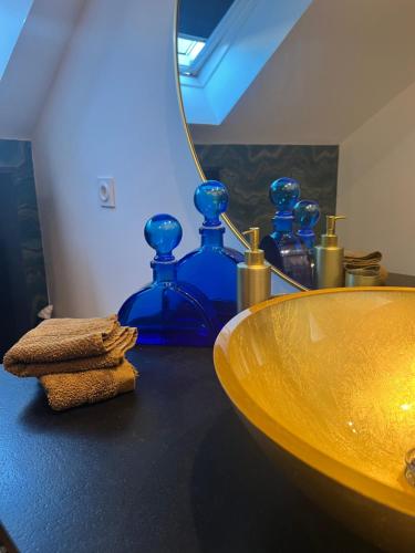 a bathroom with a sink and blue glass bottles at Lucifer SPAS in Dijon