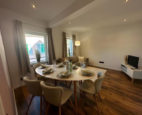 ein Esstisch und Stühle in einem Wohnzimmer in der Unterkunft Charmante Ferienwohnung mit großer Dachterrasse & Wintergarten in Gau-Algesheim