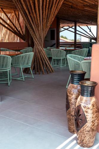 two vases sitting on a patio with chairs and tables at Arrey Boutique Hotel in Barra Grande