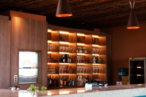 a bar with bottles and glasses on a wall at Arrey Boutique Hotel in Barra Grande