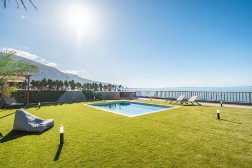 a backyard with a swimming pool and a view of the ocean at Hilani House by Homie in São Vicente