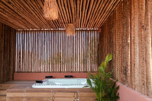 a bath tub in a room with a bamboo wall at Arrey Boutique Hotel in Barra Grande