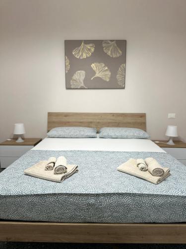 a bed with two towels on top of it at Edens house con parcheggio privato in Rapallo