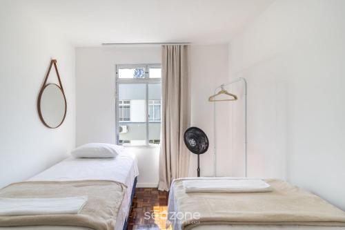 um quarto branco com duas camas e uma janela em Apartamento Aconchegante Bem Localizado RBE0031 em Florianópolis