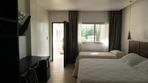 a hotel room with two beds and a window at Hotel Oaky in Posadas