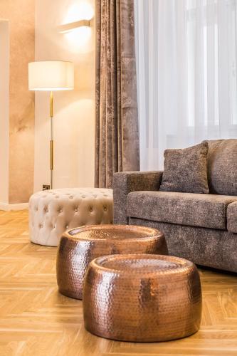 a living room with two wooden stools in front of a couch at Designer Boutique Apartments Graz Trauttmansdorffgasse in Graz