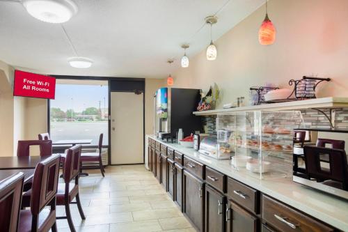 a fast food restaurant with a counter and chairs at HomeTowne Studios by Red Roof Huntsville - Madison in Madison