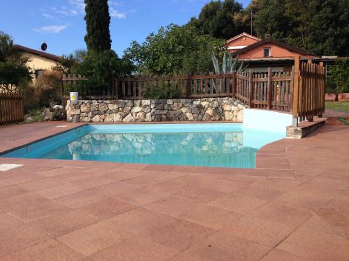 a swimming pool with a stone wall and a fence at Agriturismo "La Rosa Canina" in Lerici