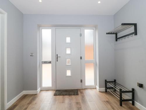 an empty hallway with a white door with windows at Ranbir House in Longhope