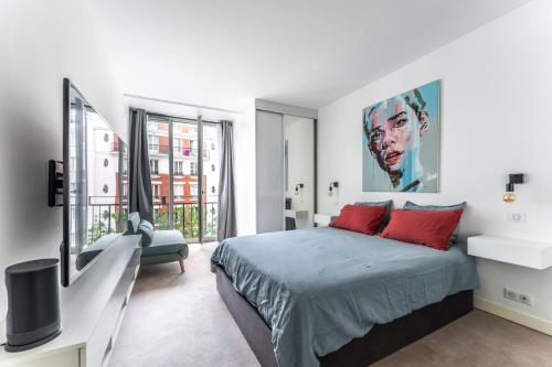 une chambre avec un lit avec des oreillers rouges dans l'établissement Paris 16 - Appartement entier - Chez Penny, à Paris