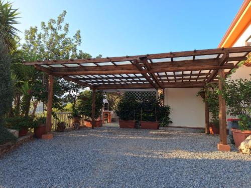 a wooden pergola in a yard with potted plants at Inteserras in Triei