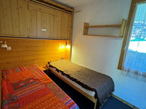 une chambre avec deux lits et une fenêtre dans l'établissement Bel appartement 2 pièces, skis aux pieds, balcon, vue pistes - FR-1-181-2417, à La Plagne Tarentaise
