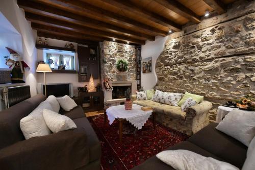 a living room with couches and a stone wall at La Villa De Rosses- Sana Halkidiki in Saná