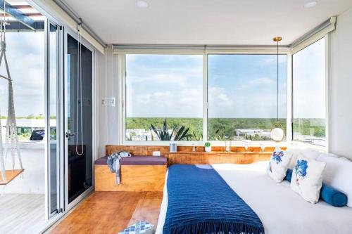 a bedroom with a large window and a large bed at 3BR Penthouse with Rooftop Pool Near Centro in Tulum