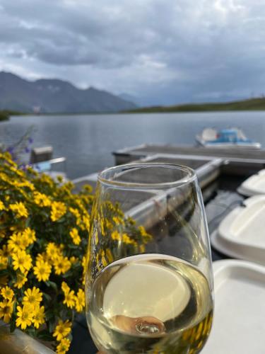 a glass of wine sitting on a table next to flowers at Chalet La Montanara in Bettmeralp