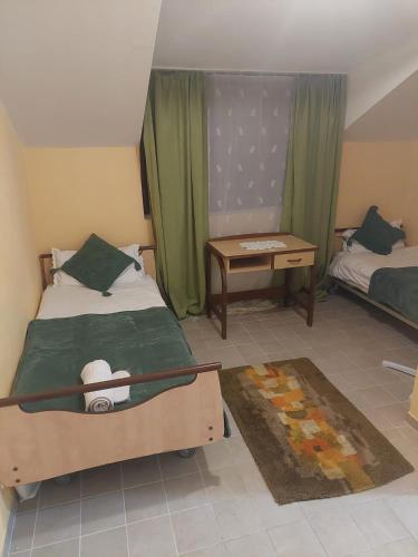 a bedroom with a bed and a table and a bed and a desk at Casa Emilia Ana Maria in Recaş