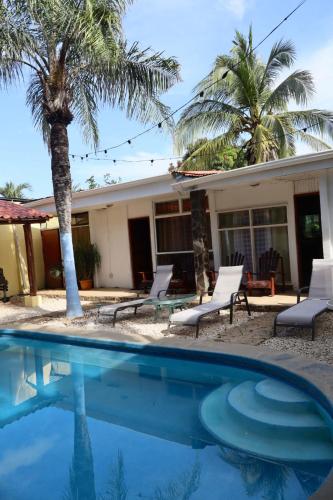 a house with palm trees and a swimming pool at Coconut Beach House in Playa Conchal
