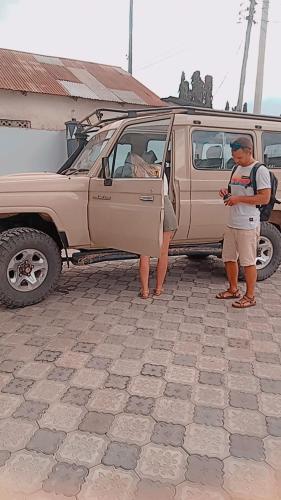 a man and a woman standing next to a vehicle at Secret hotel in Dar es Salaam