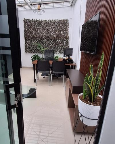 an office with a table and chairs and a plant at Hotel Zaclordy in Ubaté
