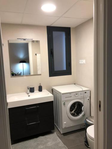 a bathroom with a washing machine and a sink at Luxury Apartment in Fuengirola