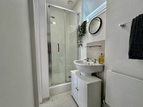 a white bathroom with a sink and a shower at Wothorpe House, 4 bed, Stamford Centre by Belmont Places in Lincolnshire