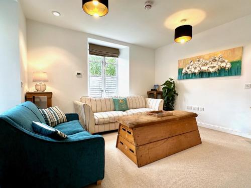 a living room with a couch and a table at Wothorpe House, 4 bed, Stamford Centre by Belmont Places in Lincolnshire