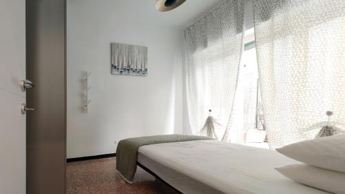 une chambre blanche avec un lit et une fenêtre dans l'établissement Appartamenti Caprice, à Diano Marina