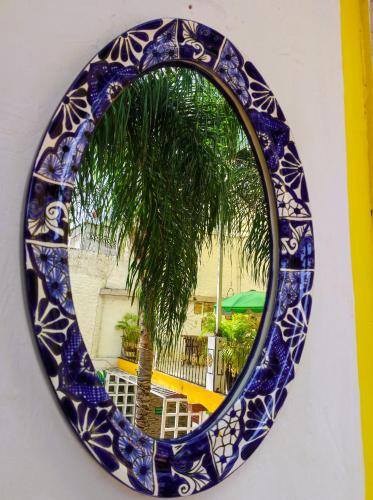 a blue glass mirror with a palm tree in the reflection at Hotel Colonial in Yautepec