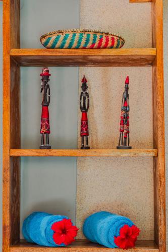 a shelf with two wooden figurines and two blue pillows at TIANDE Boutique Hotel in Pwani Mchangani