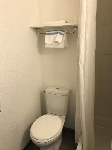 La petite salle de bains est pourvue de toilettes blanches et de serviettes. dans l'établissement Brit Hotel Essentiel Deltour Mende, à Mende
