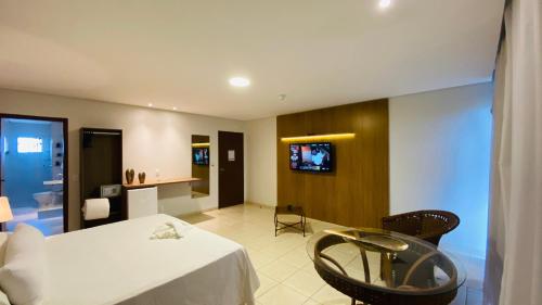 a hotel room with a bed and a tv at Hotel Nova Aliança in Chapadão do Sul