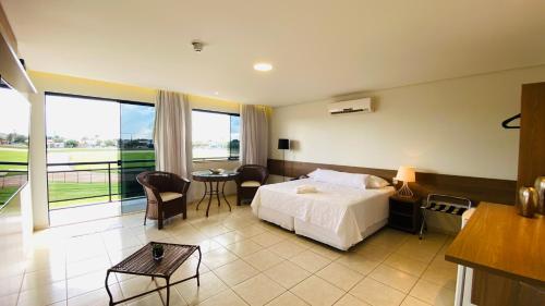 a hotel room with a bed and a balcony at Hotel Nova Aliança in Chapadão do Sul