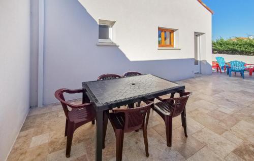- une table et des chaises noires dans la chambre dans l'établissement Amazing Home In La Tranche Sur Mer, à La Tranche-sur-Mer