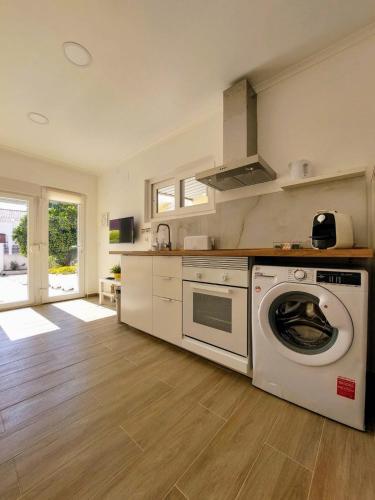 a kitchen with a washer and dryer in it at Caparica Studio - Sclusive Stay in Costa da Caparica