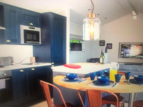 a kitchen with blue cabinets and a table with chairs at The Heather Lodge in Leven-Fife