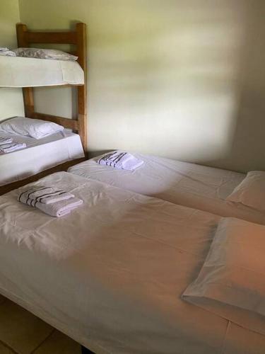 two beds sitting next to each other in a room at Sítio Gramado Sarapuí, lazer, conforto e diversão in Alambari