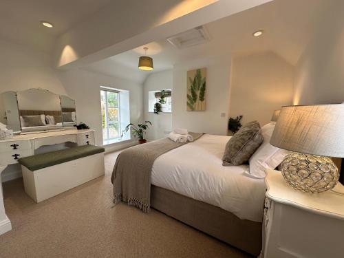 a bedroom with a large bed and a mirror at Wothorpe House, 3 bed Stamford Centre by Belmont Places in Lincolnshire