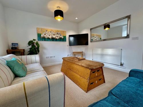 a living room with a couch and a table at Wothorpe House, 3 bed Stamford Centre by Belmont Places in Lincolnshire
