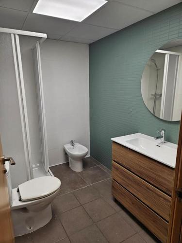 a bathroom with a toilet and a sink and a mirror at La Tallada in Caspe