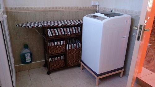 a small refrigerator in a room with some baskets at Suntoo Villa Wind & Kitesurf Accommodation in La Gaulette