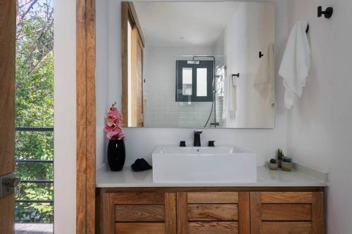 a bathroom with a white sink and a mirror at Private Rooftop Pool - Bike to Ruins or Beach in Tulum