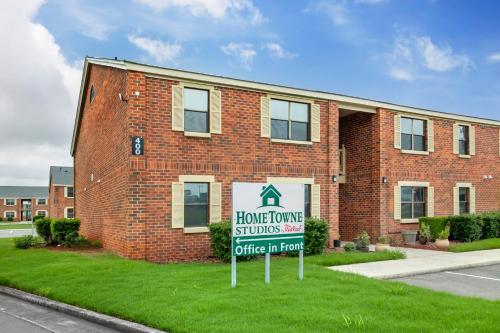 a home house with a sign in front of a building at HomeTowne Studios by Red Roof Huntsville - Madison in Madison