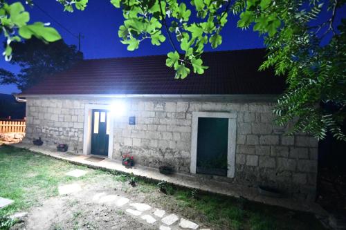 a brick house with a light at night at Agroturizam Podastrana in Hrvace
