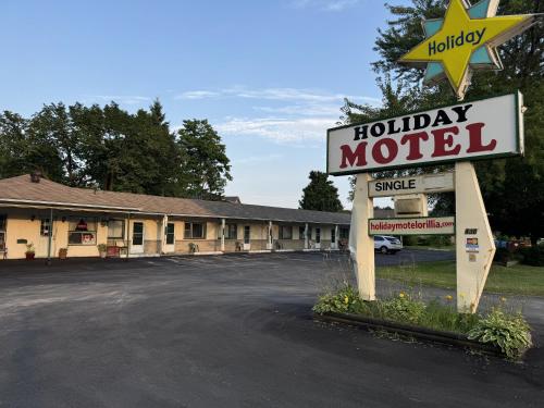 a motel sign in front of a parking lot at Holiday Motel in Orillia