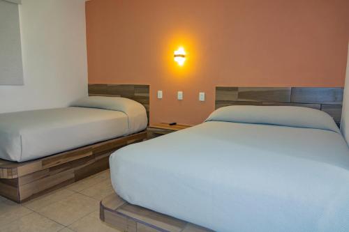 a bedroom with two beds and a light on the wall at Coral Clubes Santa María in Tlalmanalco de Velázquez